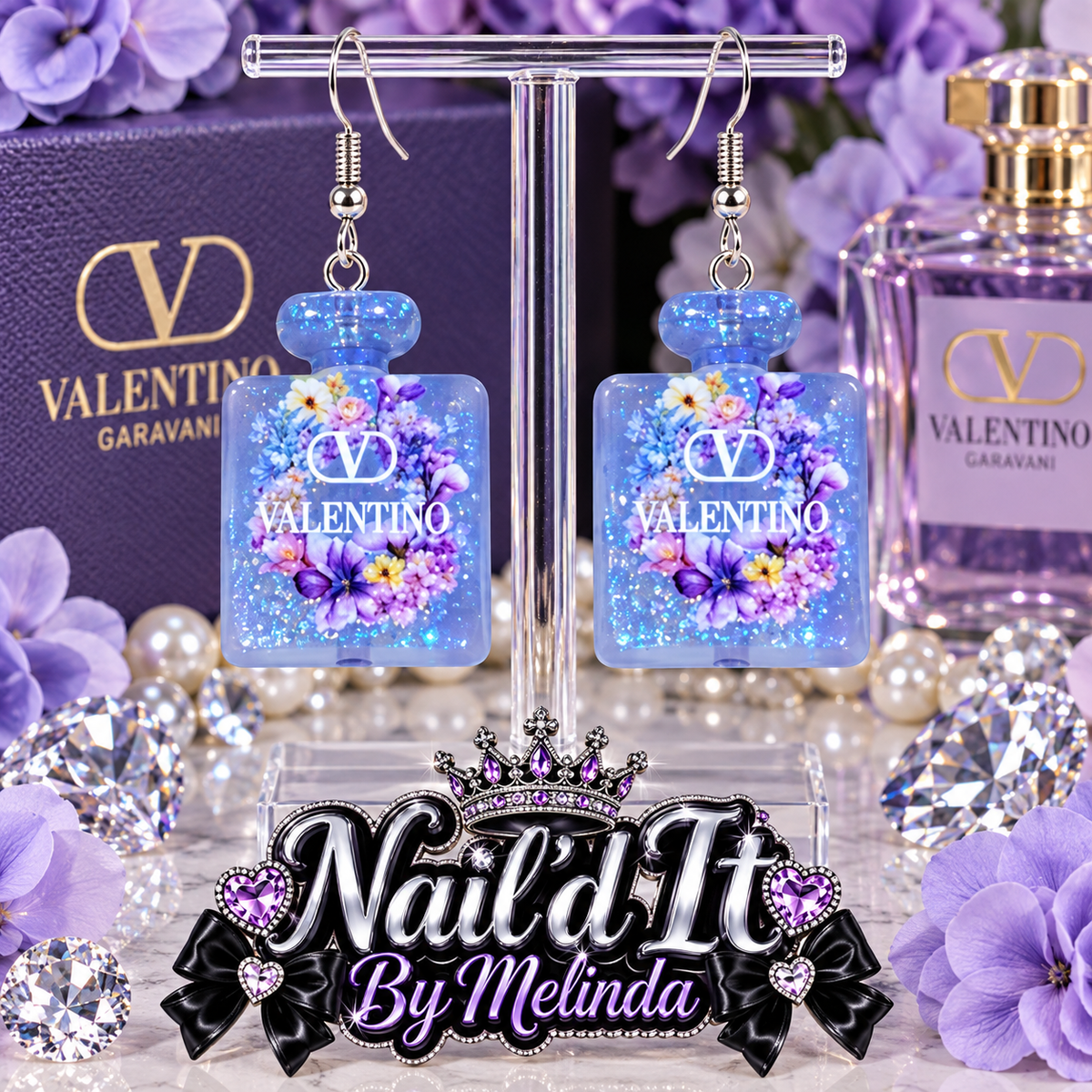 Valentino Garavani Blue Glitter Perfume Bottle Dangle Earrings on display stand with Valentino purple floral backdrop