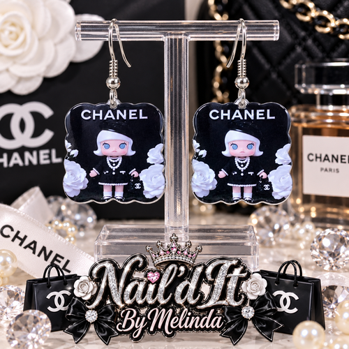 Chanel Inspired Fashion Doll Dangle Earrings on display stand with Chanel backdrop