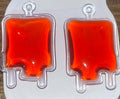 Pair of handmade red liquid blood bag charms displayed on an earring card