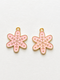 Pink enamel snowflake flower earrings with gold etching and dot accents