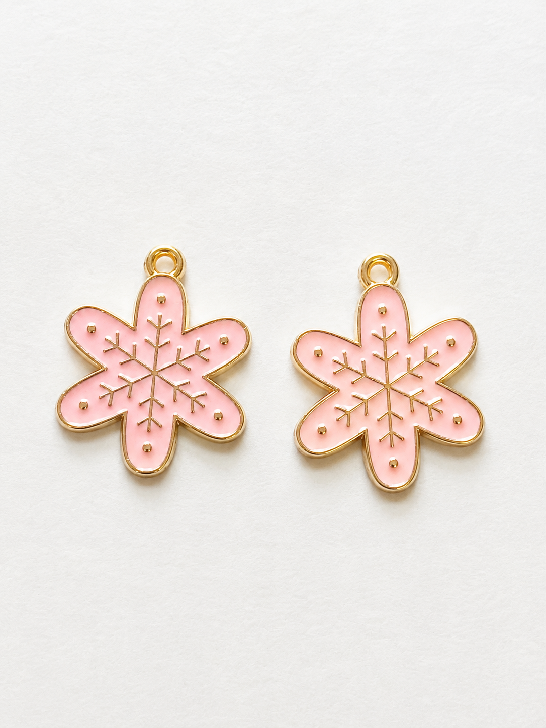 Pink enamel snowflake flower earrings with gold etching and dot accents