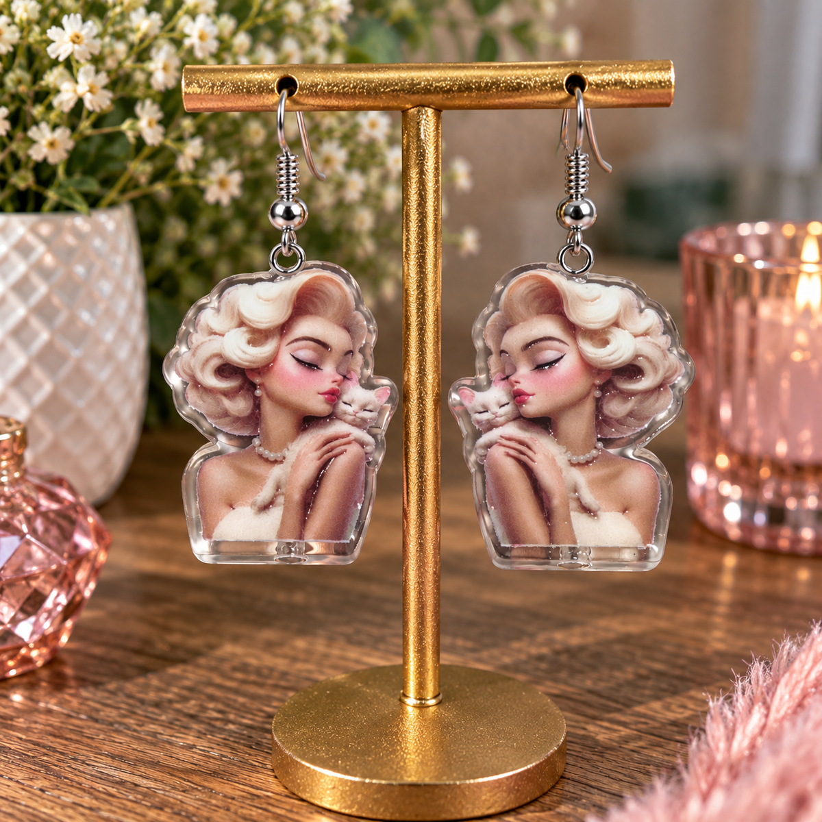 Glam girl and kitty dangle earrings on gold display stand – romantic lifestyle shot with florals