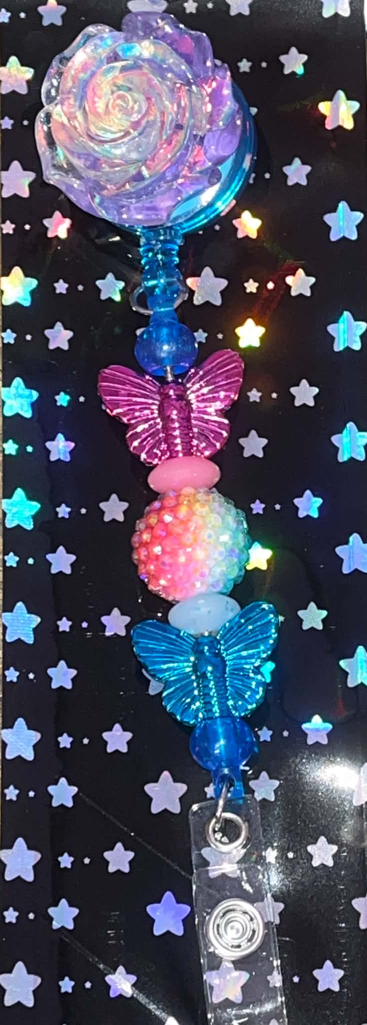 Iridescent rose retractable badge reel with pink and blue butterfly beads and rainbow accents