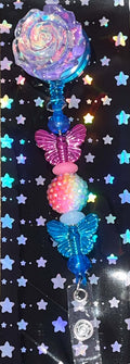 Iridescent rose retractable badge reel with pink and blue butterfly beads and rainbow accents