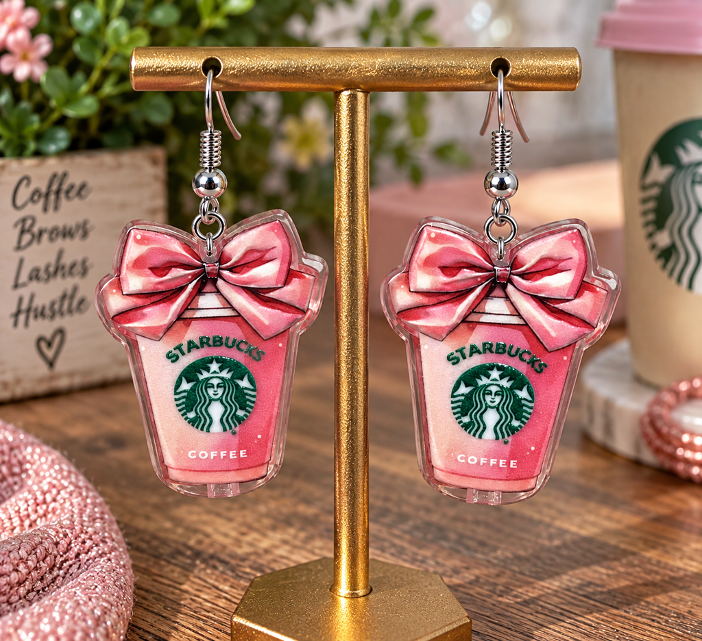 Starbucks pink cup dangle earrings with pink bow on gold display stand – Nail'd It By Melinda branded lifestyle shot